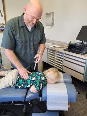 Chiropractor Oshkosh WA Michael Marchese Adjusting Child